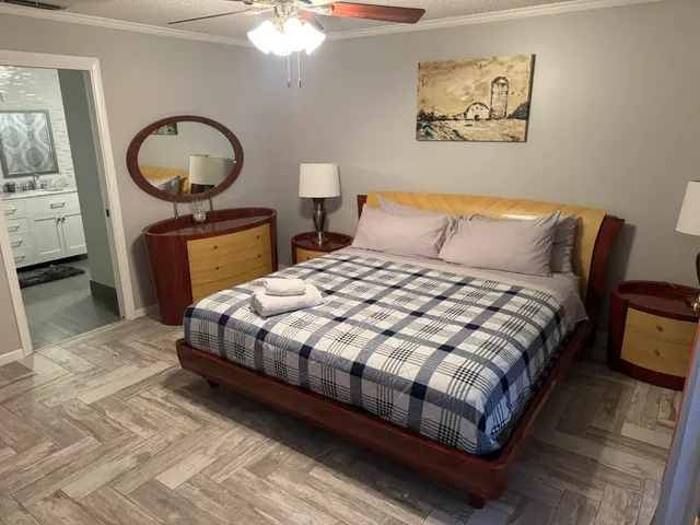 a bedroom with a bed a mirror and painting on the wall