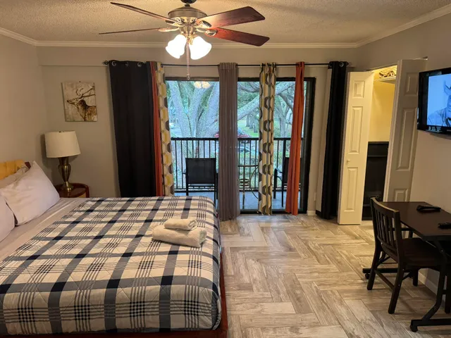 a bedroom with a large bed and a flat tv screen