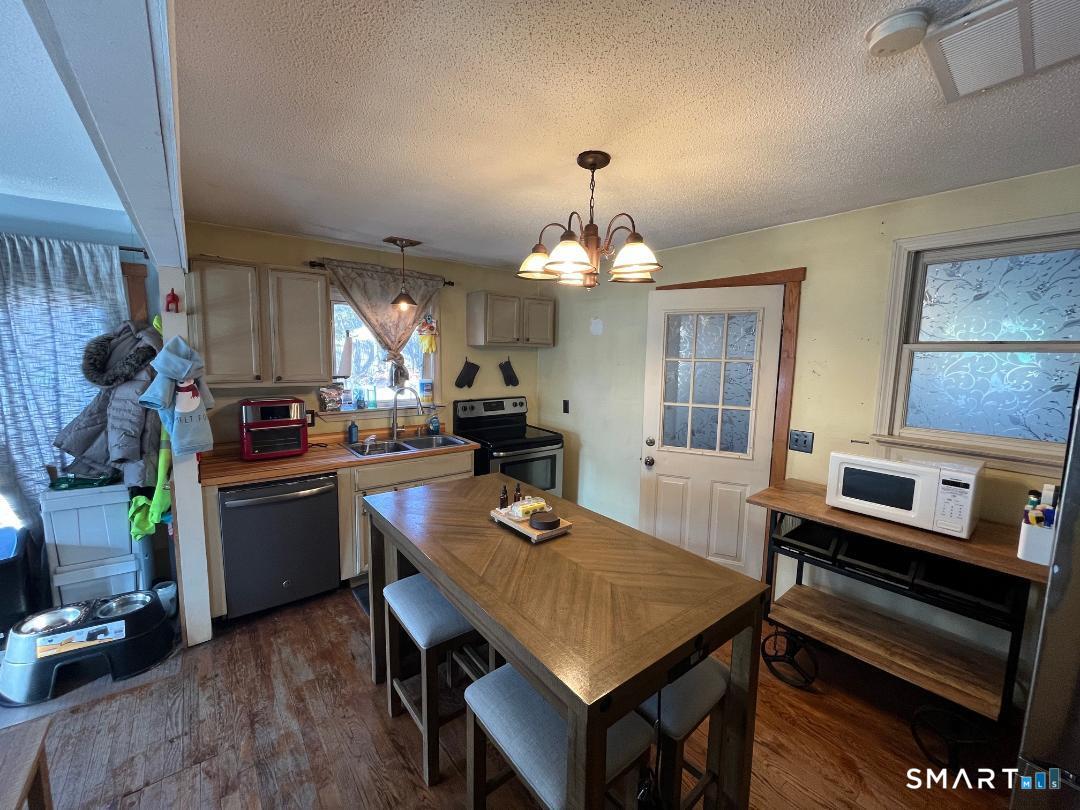 61 Tankerhoosen Road Vernon, CT 06066 - Photo 13 of 34 a kitchen with a table chairs and refrigerator