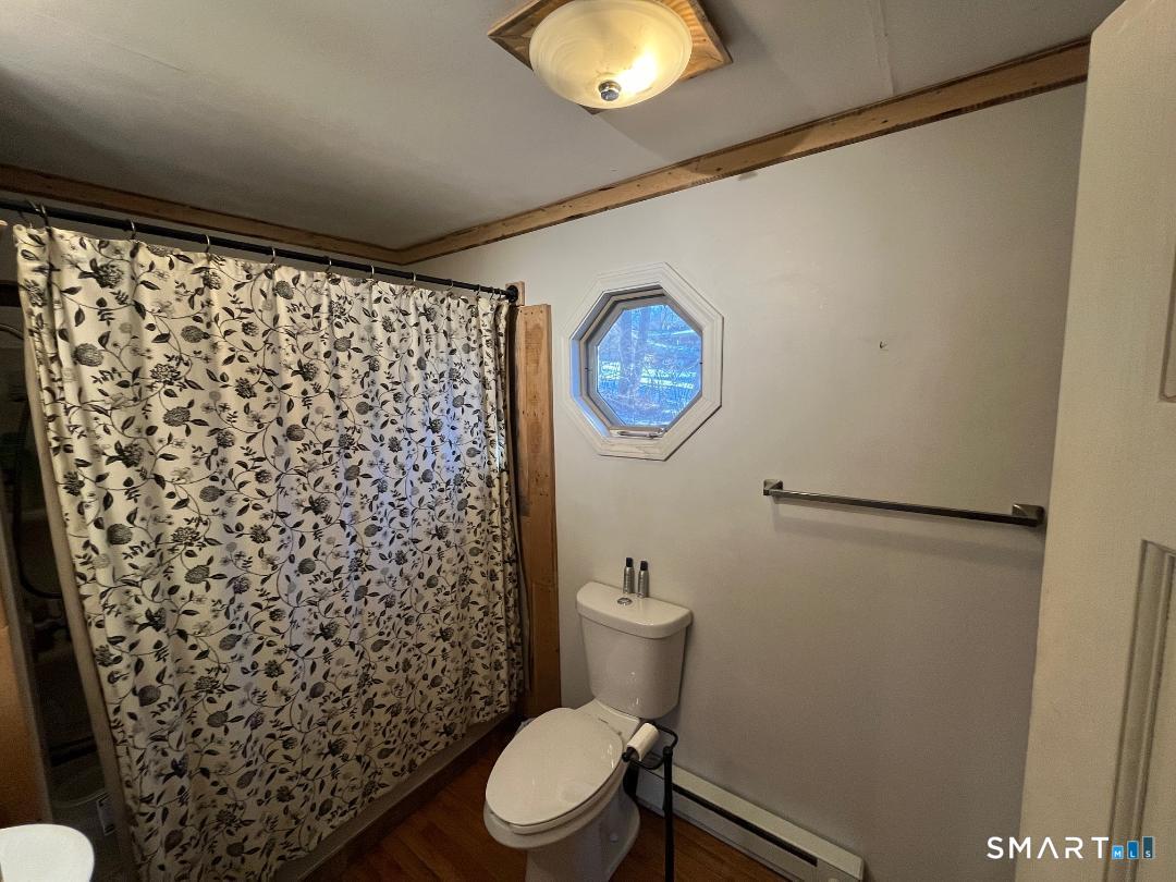 61 Tankerhoosen Road Vernon, CT 06066 - Photo 17 of 34 a bathroom with a toilet and a shower curtain