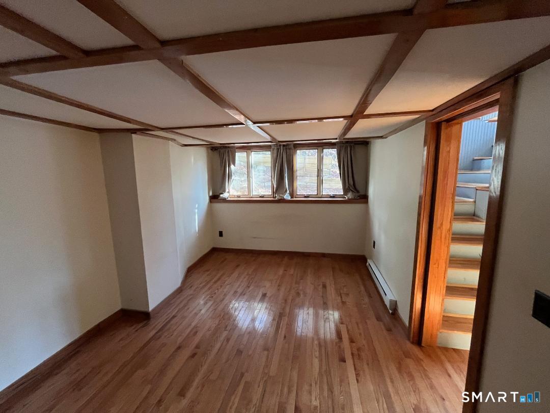 61 Tankerhoosen Road Vernon, CT 06066 - Photo 23 of 34 an empty room with wooden floor and windows