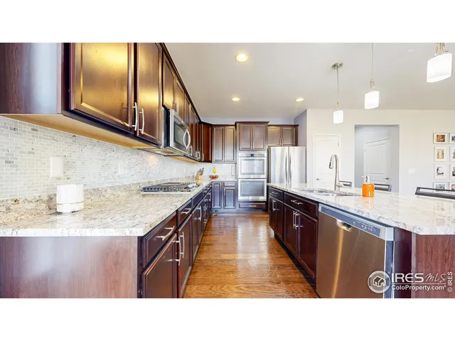 a kitchen with stainless steel appliances granite countertop a sink stove and cabinets