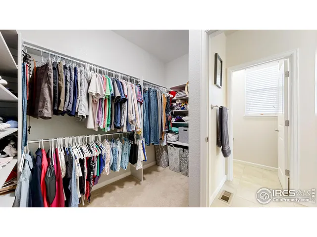 a view of walk in closet with clothes and shoes