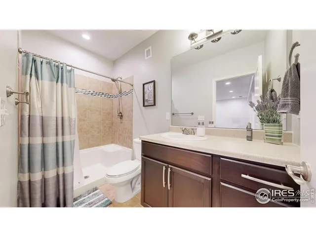 a bathroom with a sink a toilet a mirror and shower