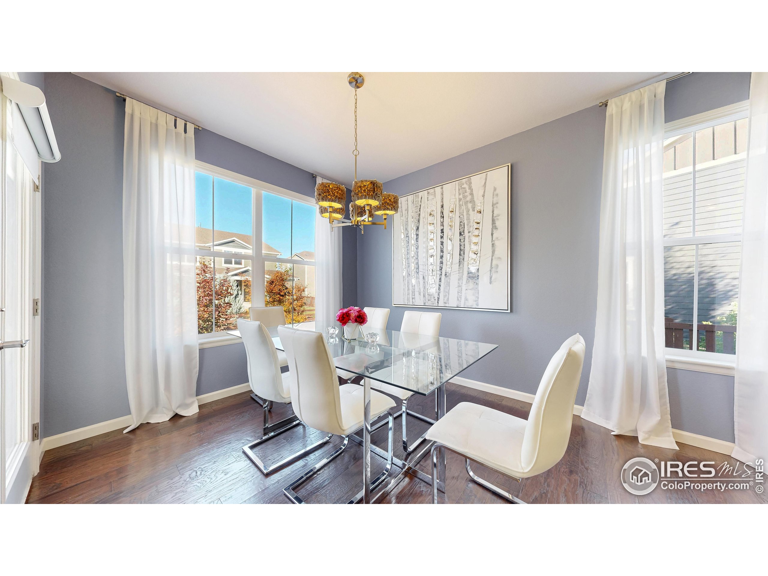 6794 Spring Rain Road Timnath, CO 80547 - Photo 6 of 49 a living room with furniture a table and a chandelier