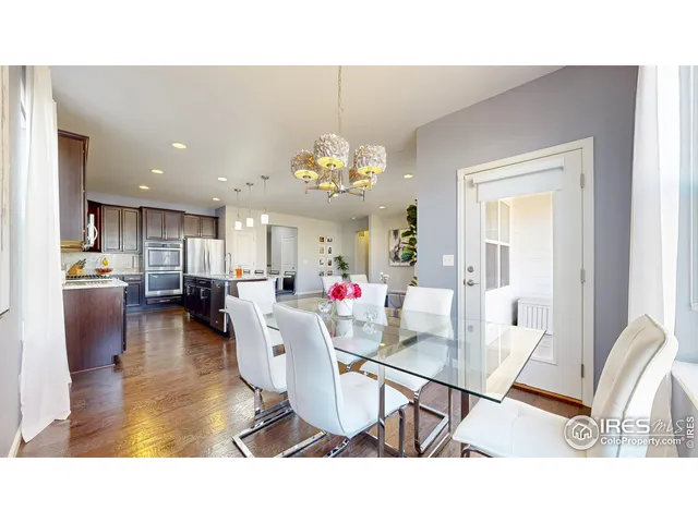 a living room with dining table and a chandelier