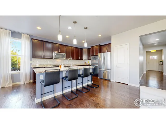 a kitchen with a dining table chairs refrigerator and window