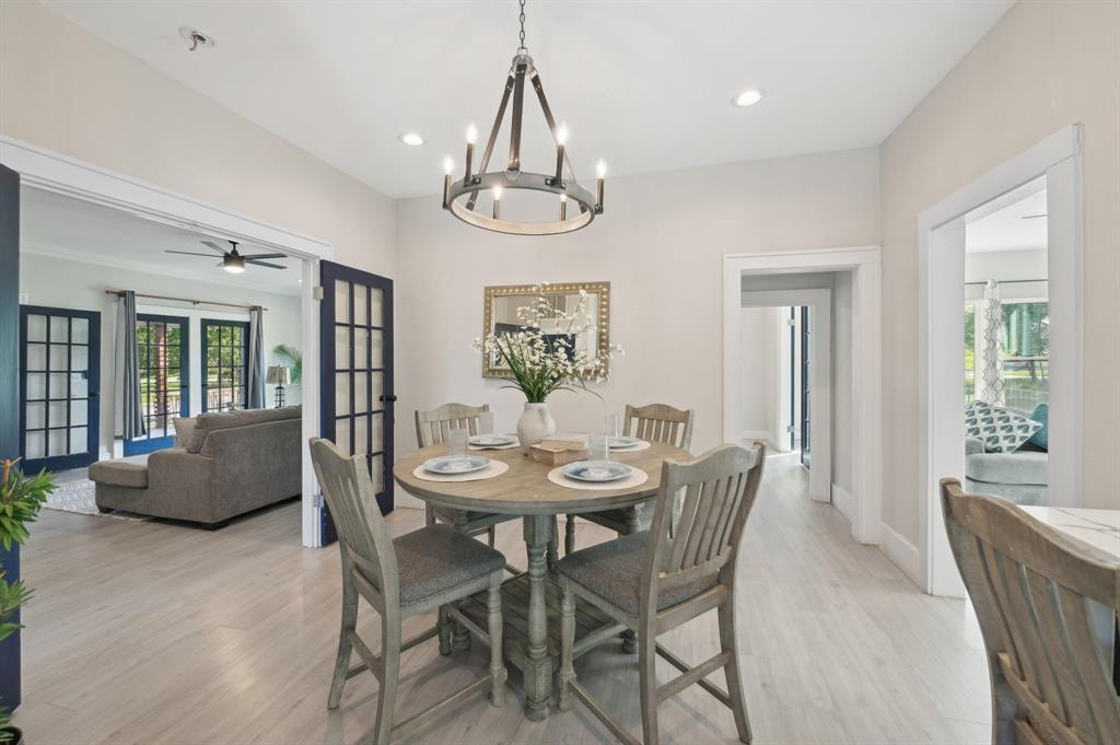 702 Griffith Avenue Terrell, TX 75160 - Photo 13 of 40 a dining room with wooden floor a chandelier a glass table and chairs