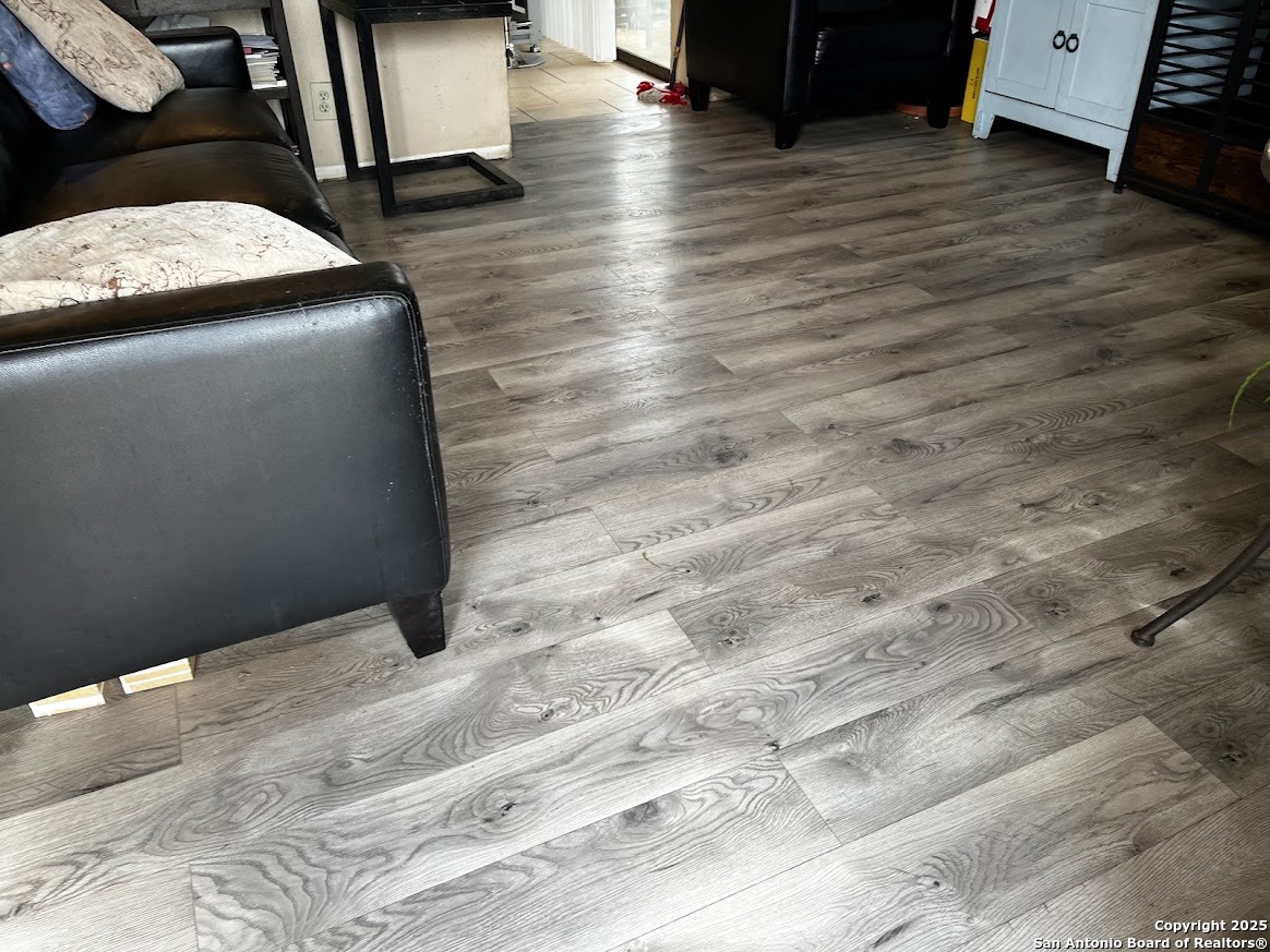 6613 Pebble Spring Drive San Antonio, TX 78249 - Photo 6 of 11 a view of an empty room with wooden floor and a window