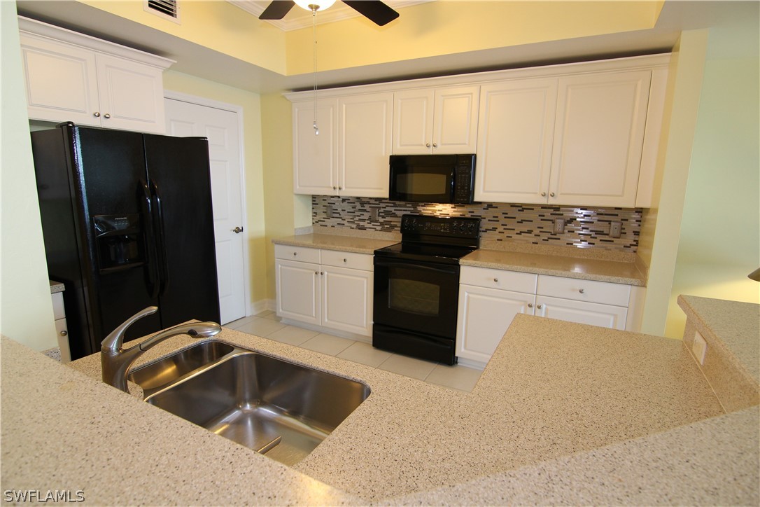 2797 First Street, Unit 804 Fort Myers, FL 33916 - Photo 11 of 34 a kitchen with granite countertop a sink and a stove top oven