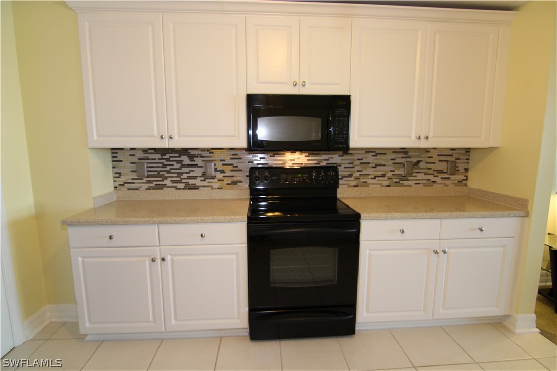 2797 First Street, Unit 804 Fort Myers, FL 33916 - Photo 13 of 34 a kitchen with white cabinets and black appliances