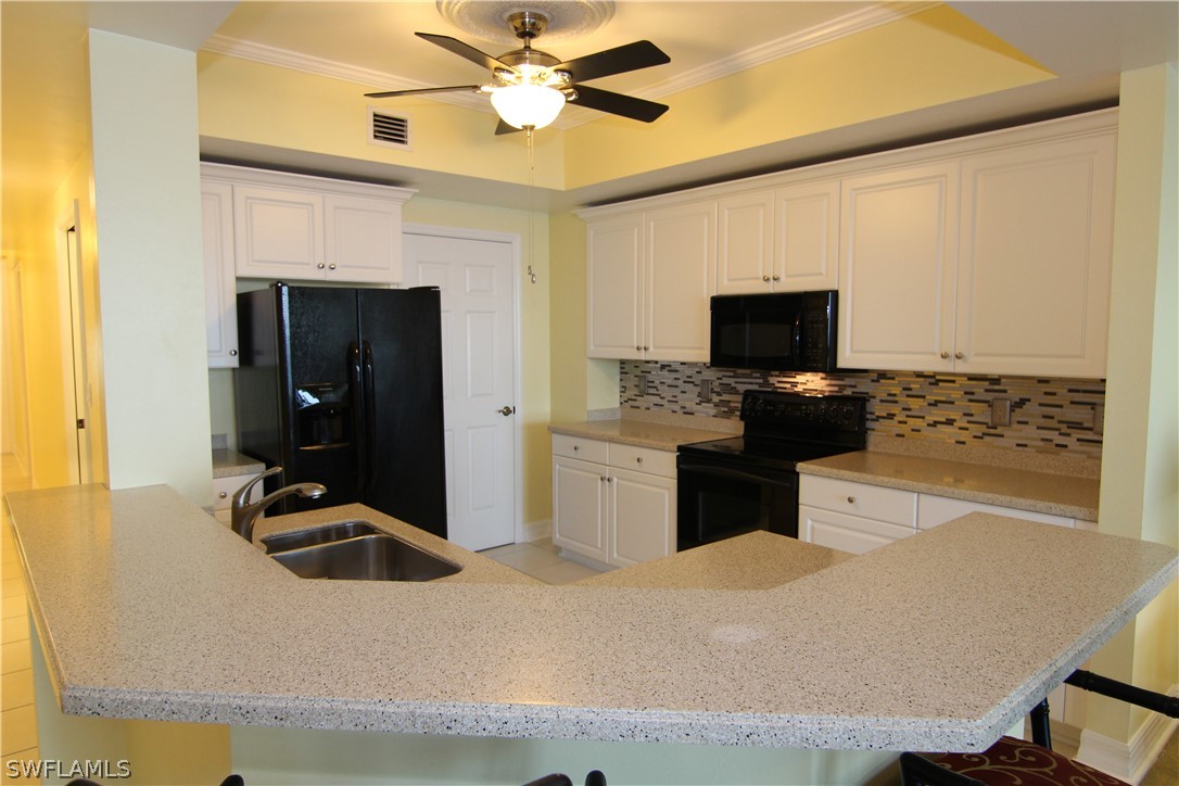 2797 First Street, Unit 804 Fort Myers, FL 33916 - Photo 9 of 34 a kitchen with a refrigerator and a sink