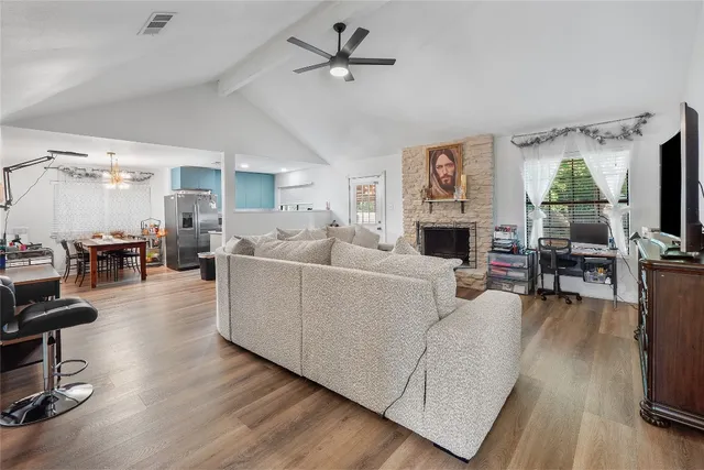 a living room with furniture dining table a flat screen tv and a fireplace
