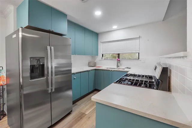 a kitchen with kitchen island a counter top space a refrigerator and cabinets