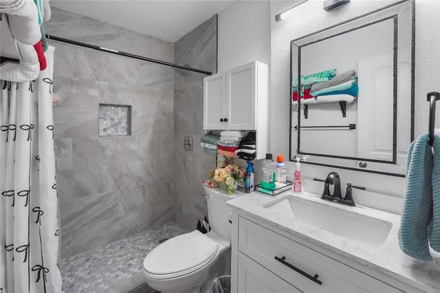 a bathroom with a sink toilet and shower