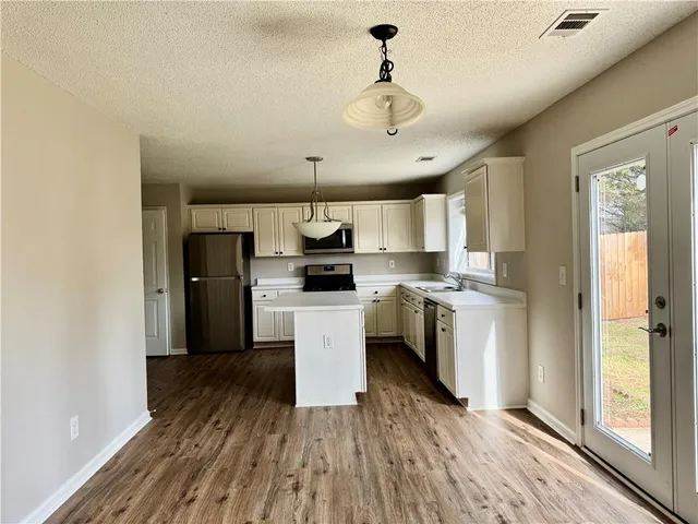 a kitchen with stainless steel appliances a refrigerator and a stove top oven
