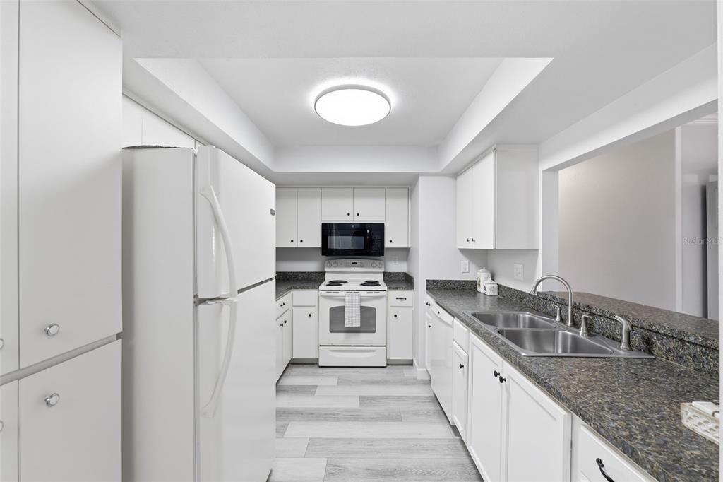 9204 Golf View Drive New Port Richey, FL 34655 - Photo 10 of 39 a large white kitchen with a refrigerator a stove top oven a sink and dishwasher