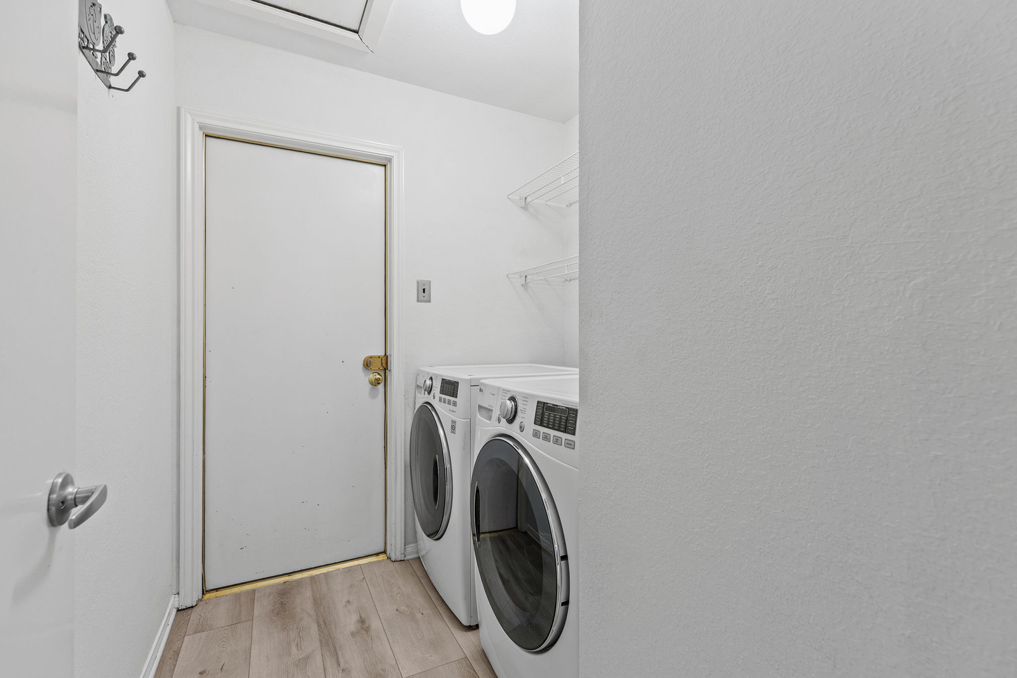 2409 Water Well Lane Austin, TX 78728 - Photo 19 of 22 Dedicated laundry area featuring wood-finish flooring, white walls, and built-in wire shelving