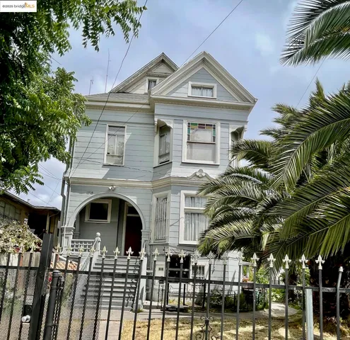 a front view of a house with glass windows and palm trees