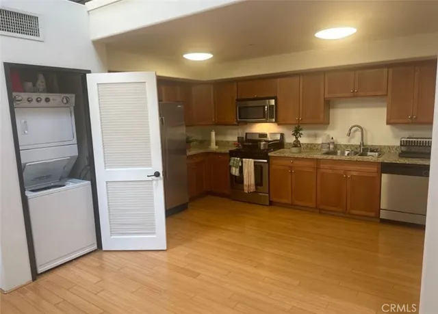 a kitchen with stainless steel appliances granite countertop a sink stove and refrigerator