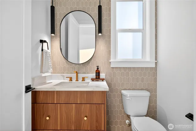 a bathroom with a toilet sink and mirror