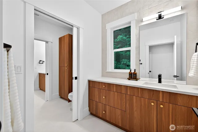 a bathroom with a double vanity sink a mirror and a window