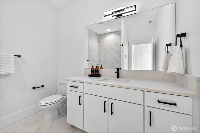 a bathroom with a sink a toilet and a mirror