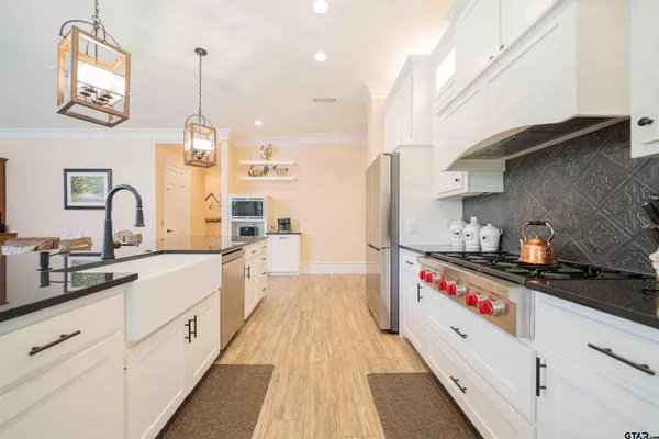 a view of a dining room and livingroom with furniture wooden floor a chandelier
