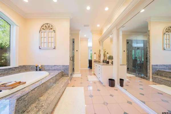 a bedroom with a large bed and a chandelier