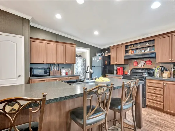 a kitchen with stainless steel appliances a table and chairs in it
