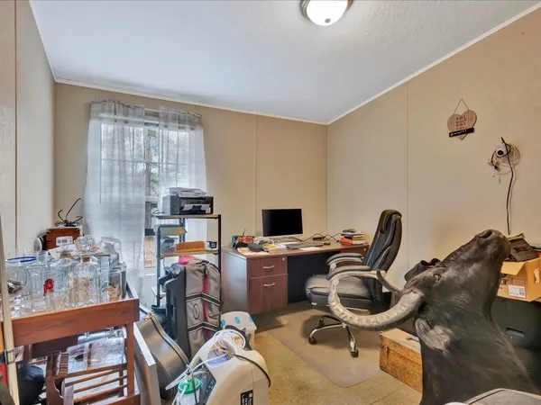a view of a workspace with furniture and a window