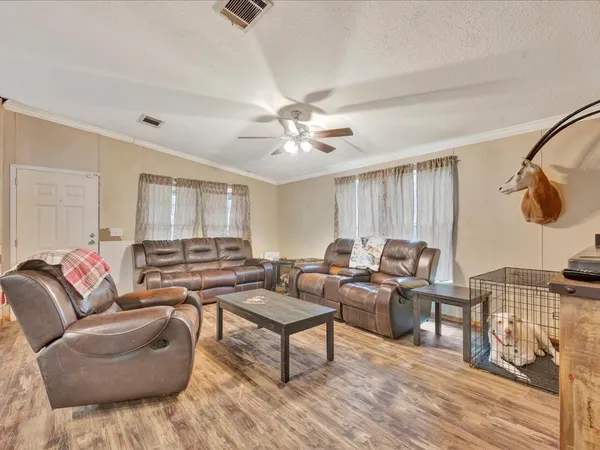 a living room with furniture and a wooden floor