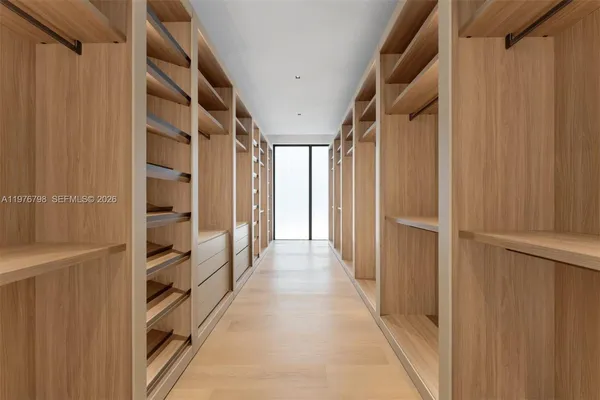 a view of a hallway with wooden shelves