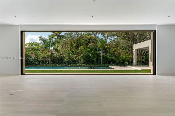 a view of empty room with floor to ceiling windows and yard
