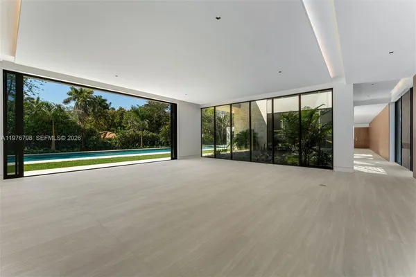 a view of an empty room with wooden floor and a floor to ceiling window