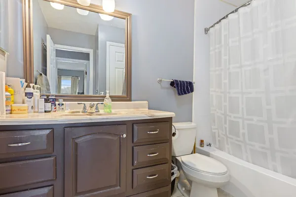 a bathroom with a granite countertop toilet a sink and a mirror