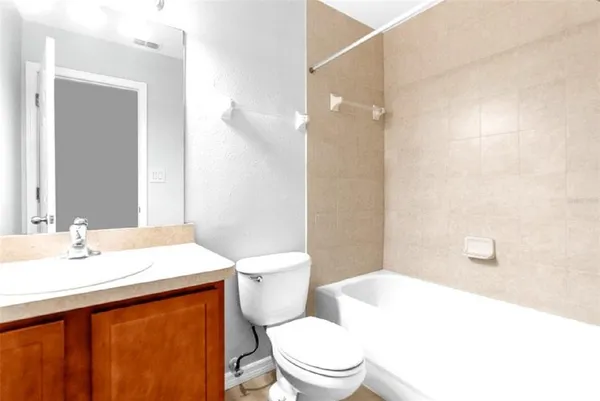 a bathroom with a sink a toilet a mirror and shower