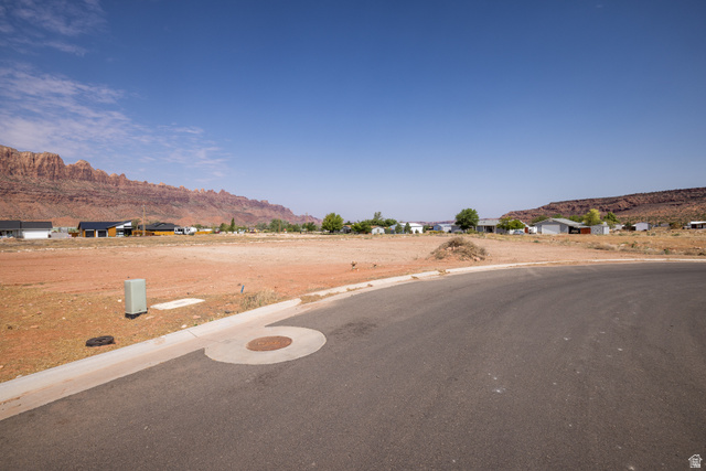 Expansive land parcel featuring a paved road frontage and surrounding desert landscape