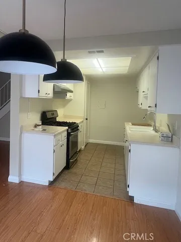 a kitchen with a sink a stove and cabinets
