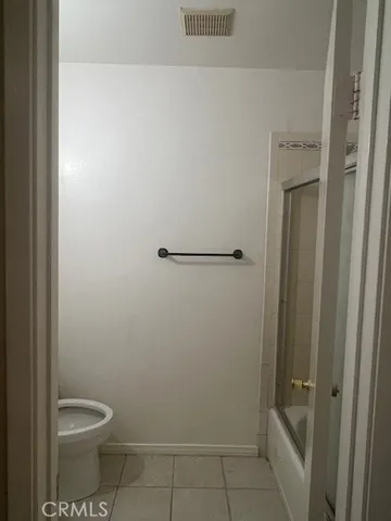 a bathroom with a granite countertop toilet and a shower