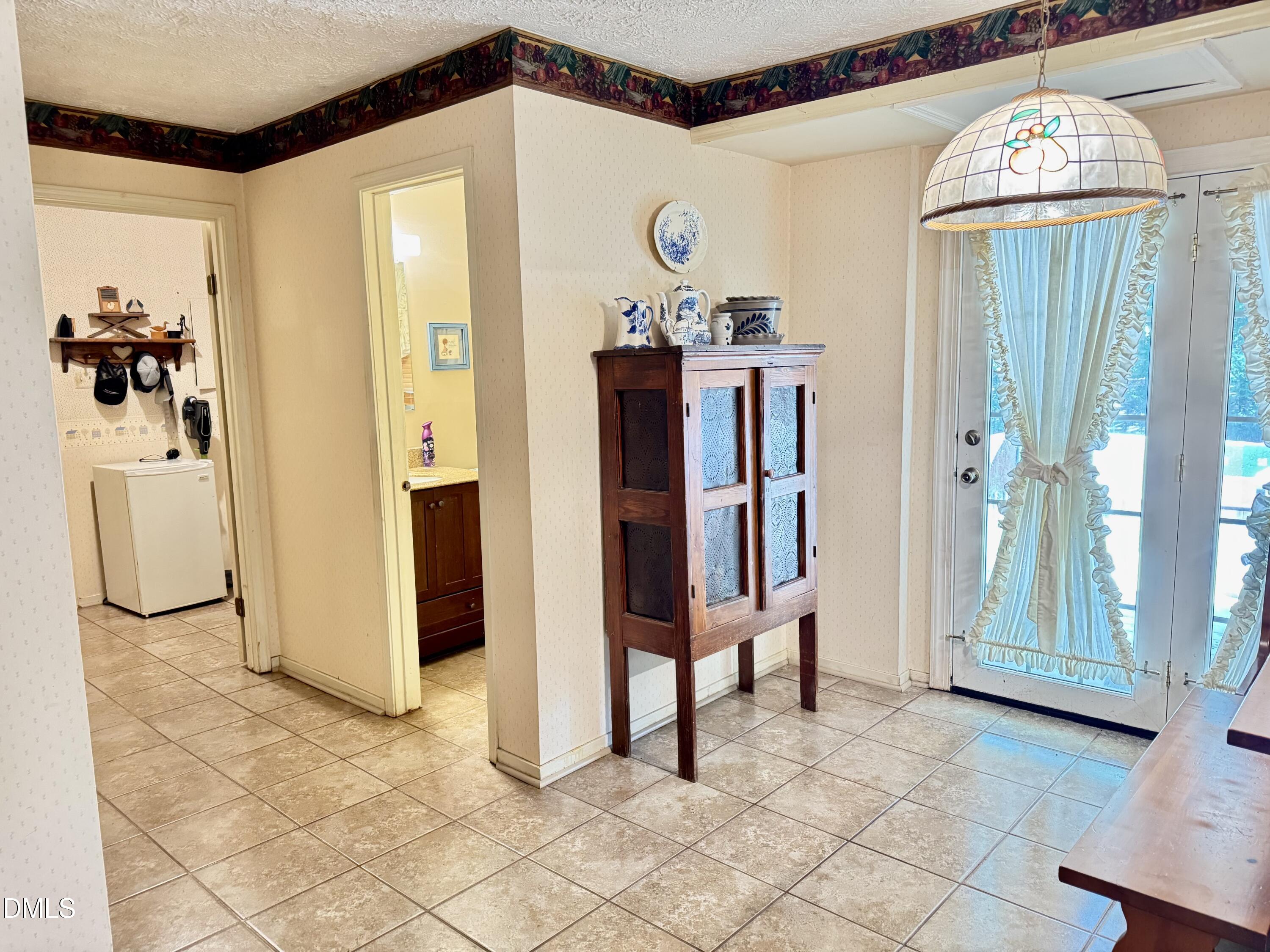 84 Wintergreen Road Henderson, NC 27537 - Photo 17 of 49 a view of a hallway and a dining room with chandelier
