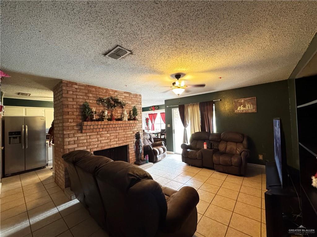 2018 West Adrian Street Harlingen, TX 78552 - Photo 5 of 13 a living room with furniture a flat screen tv and a fireplace