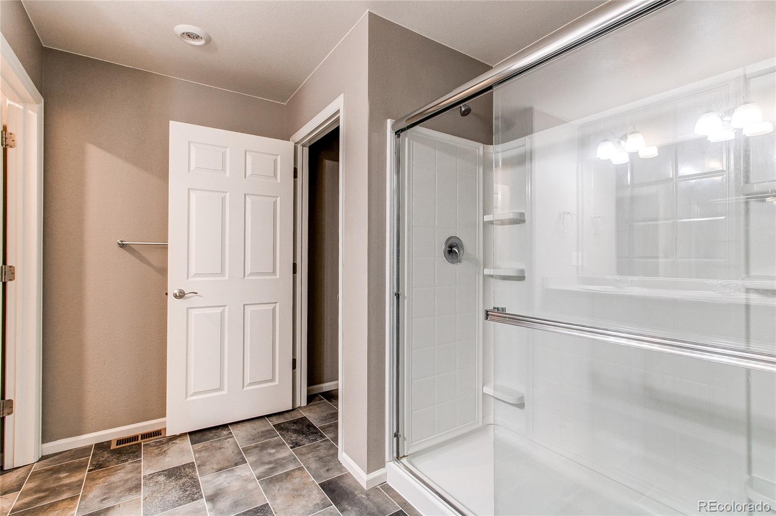 10099 Cascade Street Firestone, CO 80504 - Photo 19 of 46 a bathroom with a glass shower door and a sink