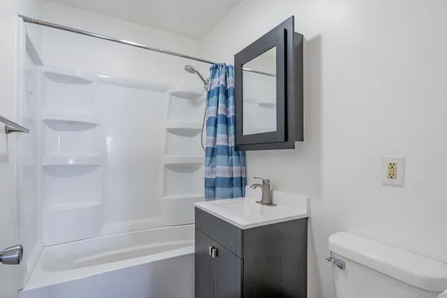a bathroom with a sink toilet vanity and shower