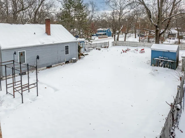 a view of a tree with snow on the road