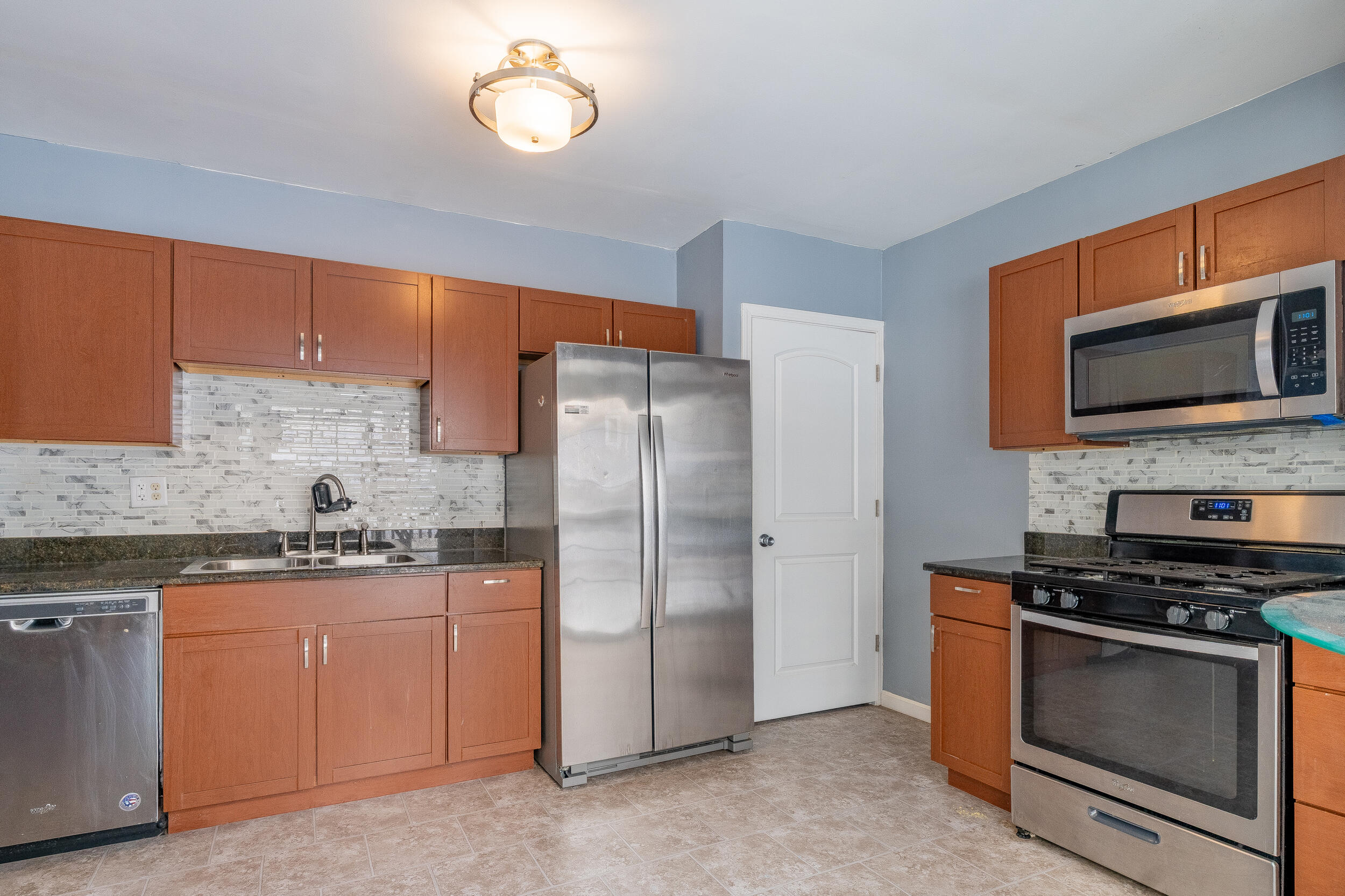 2321 Crest Road Gary, IN 46408 - Photo 9 of 22 a kitchen with stainless steel appliances granite countertop a stove a sink and a refrigerator