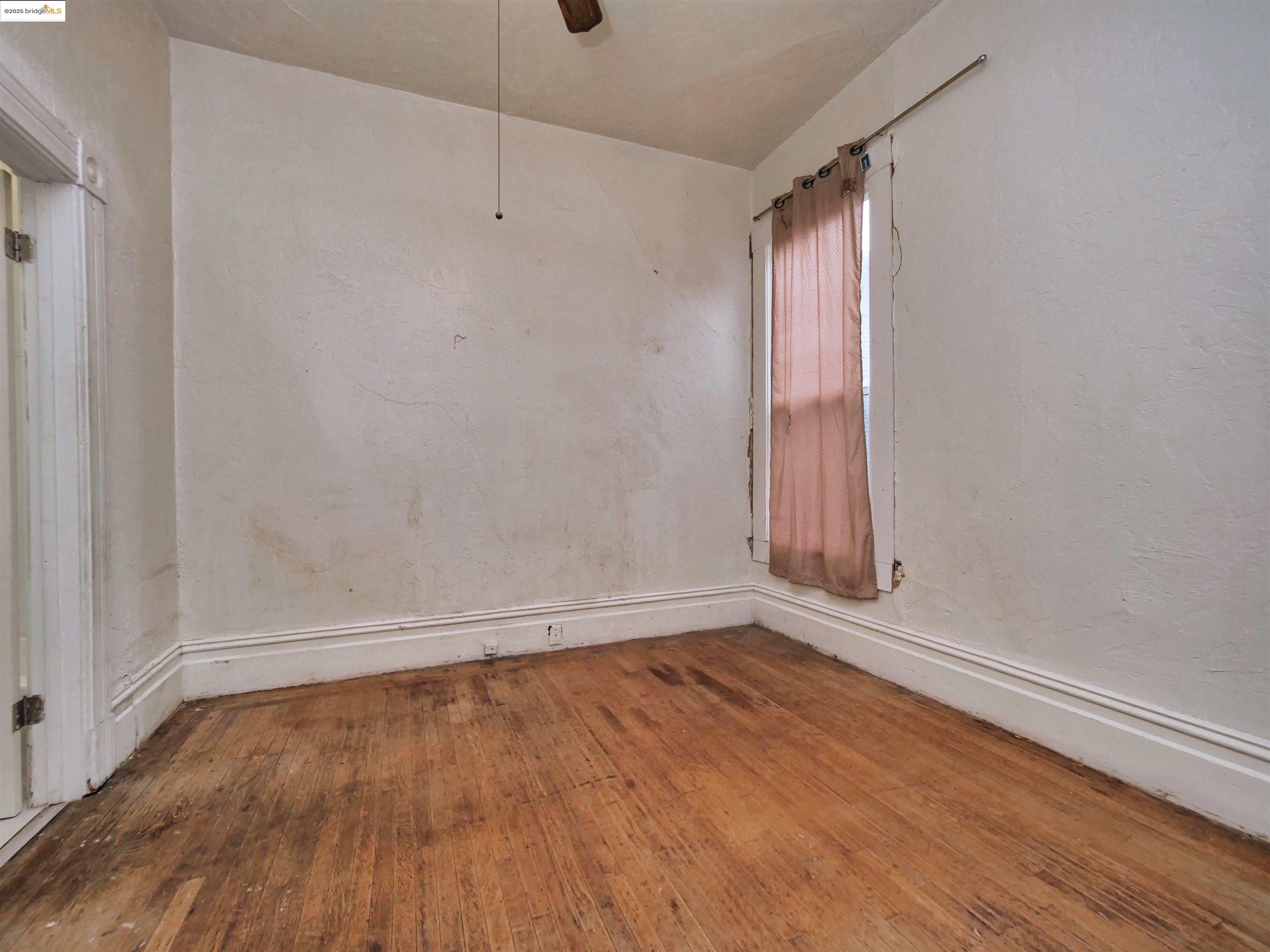 2103 Myrtle Street Oakland, CA 94607 - Photo 12 of 21 a view of an empty room with wooden floor and a window