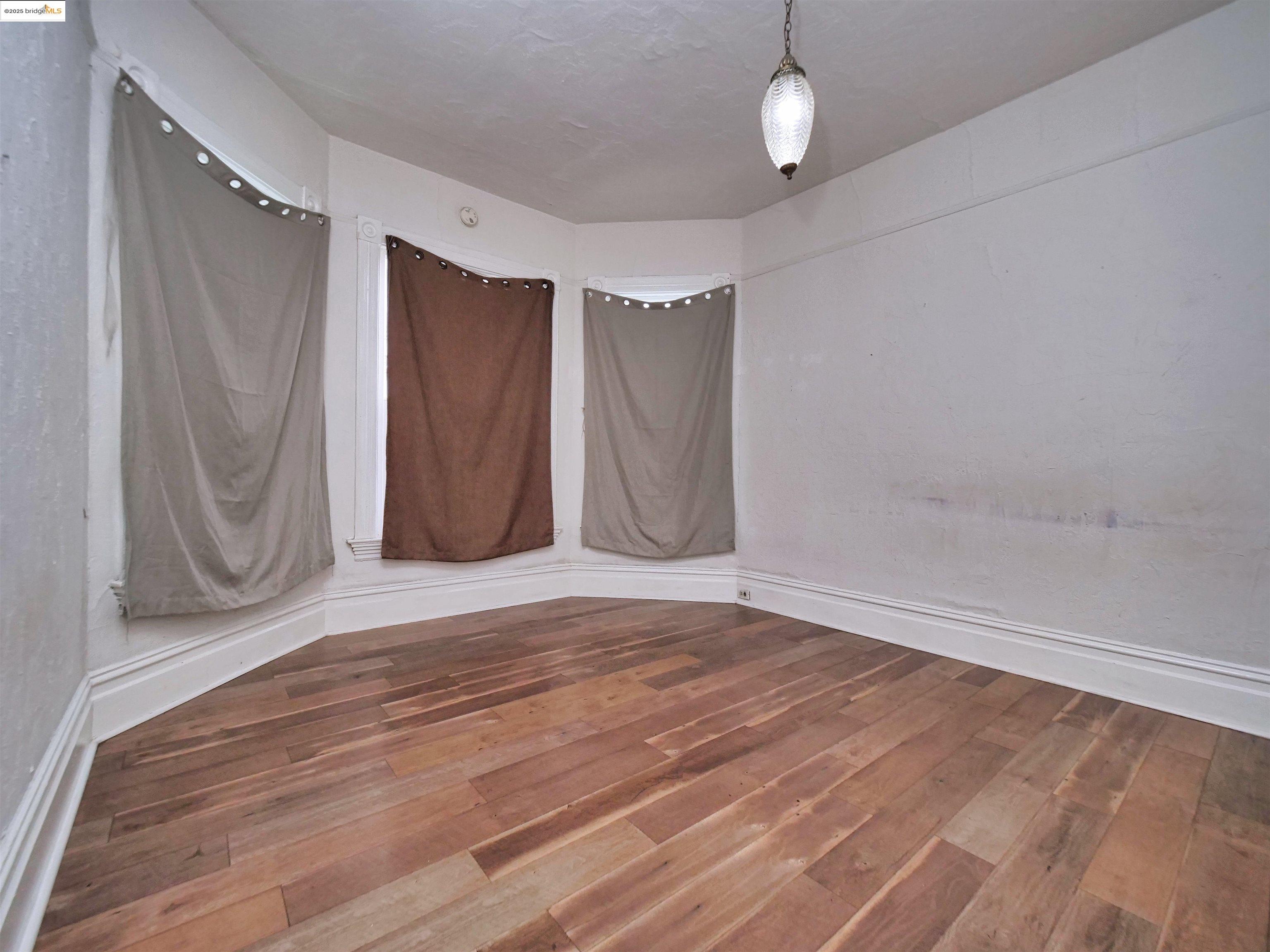 2103 Myrtle Street Oakland, CA 94607 - Photo 14 of 21 a view of empty room with wooden floor and fan