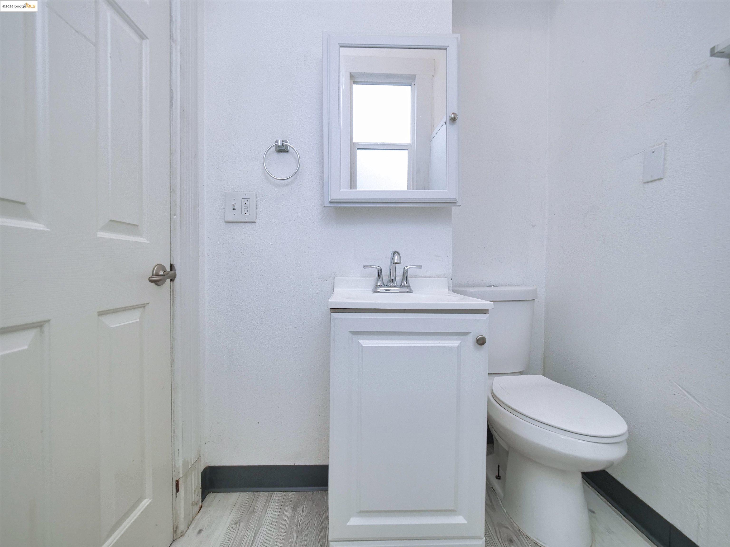 2103 Myrtle Street Oakland, CA 94607 - Photo 18 of 21 a bathroom with a toilet sink and mirror