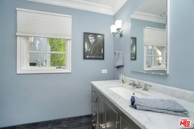 a bed sitting in a bedroom next to a window with wooden floor